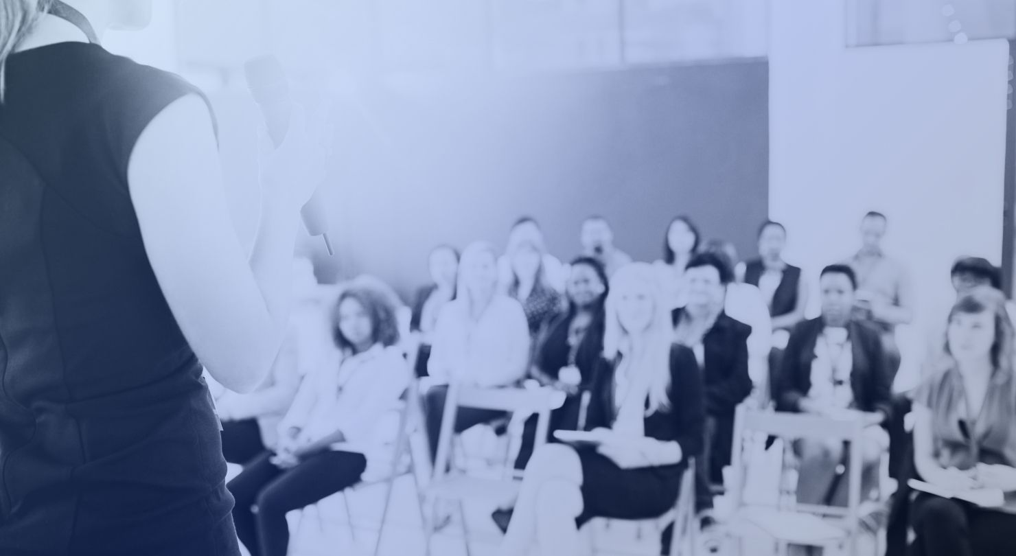 A speaker addressing a seated audience